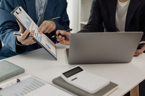 商人和女商人正在开工作会议，桌上放着许多财务文件。办公室里忙着进行商业利润分析和头脑风暴。特写照片图片下载