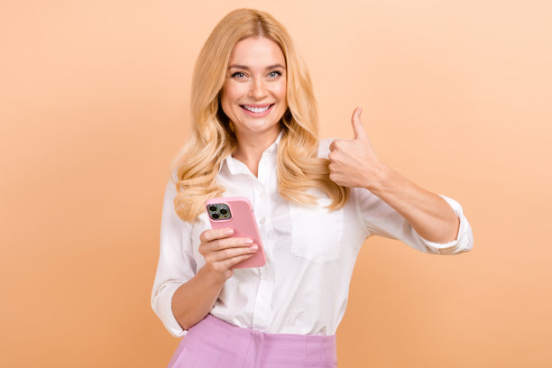 成熟的年龄妇女穿着正式的衬衫的照片大拇指推荐加入她的公关机构团队使用手机孤立的米色背景图片下载