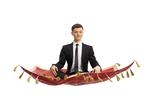 穿着黑色西装的年轻人盘腿坐在魔毯上冥想图片下载