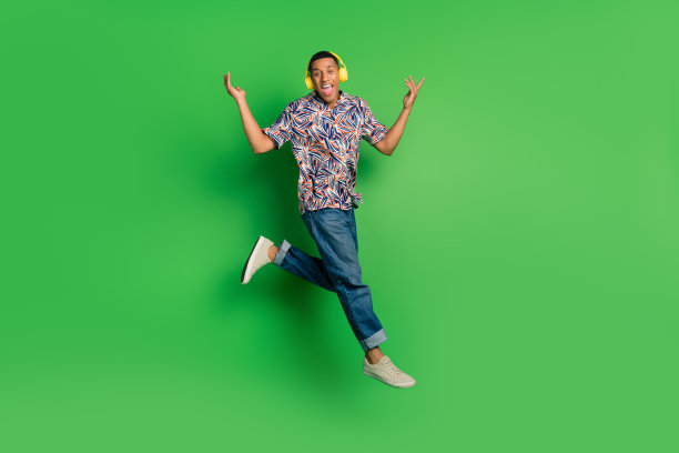 正面的全长照片凉爽的无忧无虑的男人穿着时髦的夏装听音频打孤立的绿色背景图片下载