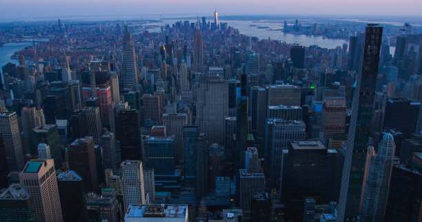 从空中俯瞰纽约曼哈顿下城的建筑。日落时从直升机上拍摄的全景市区照片。城市景观与现代办公大楼和历史悠久的摩天大楼图片下载