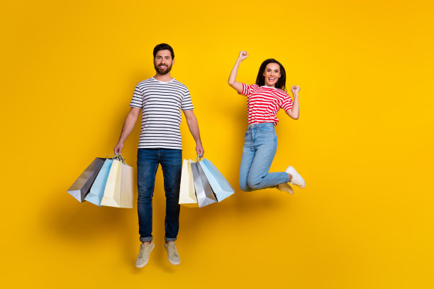 全尺寸照片的好男人满意的女孩穿着条纹t恤跳跃与新衣服在充满活力的黄色背景孤立图片下载