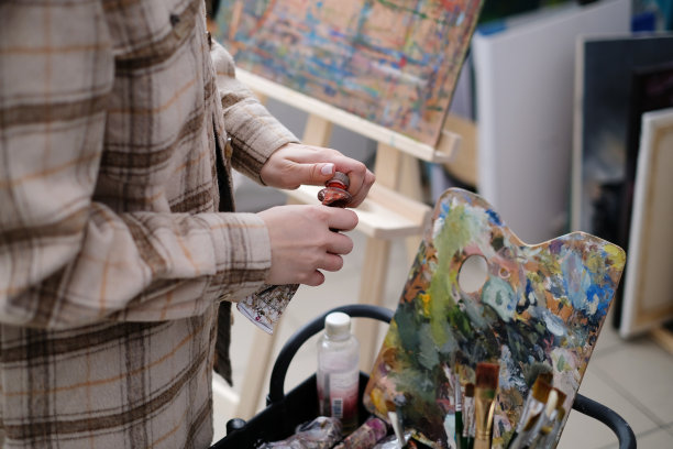 在艺术工作室里，喷溅着颜料的画笔靠近油画图片下载