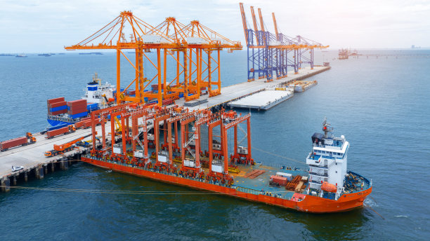 驳船上的大型工程起重机。集装箱起重机在驳船上运输货物到国际海运港口。图片下载