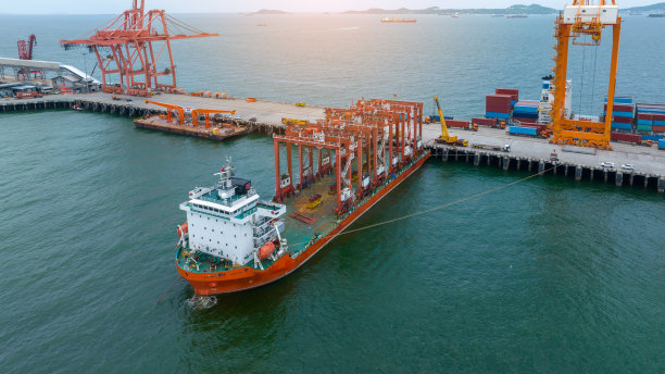 驳船上的大型工程起重机。集装箱起重机在驳船上运输货物到国际海运港口。图片下载