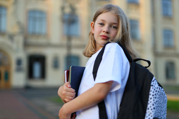背着书包，准备上学，散发着快乐和对学习的热爱的美丽女学生图片下载