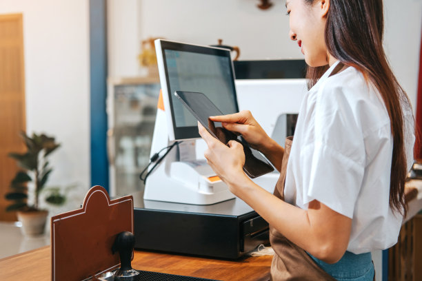 女咖啡师从咖啡机中取出一杯热腾腾的浓缩咖啡。图片下载