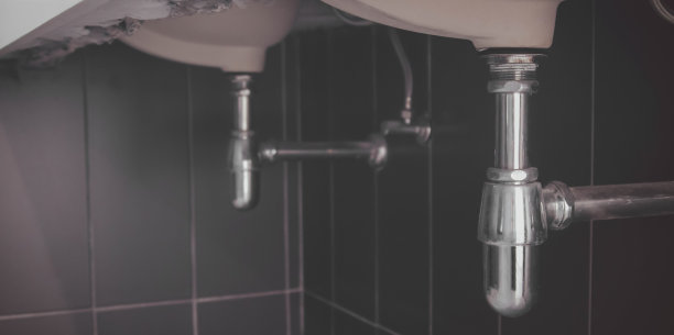 在浴室工作的水管工，管道维修服务，修理水管道泄漏，更换厨房水槽排水管图片下载