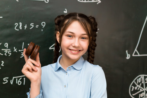 甜蜜时刻:在一张有趣的照片中，一个女学生正在享用巧克力松饼图片下载