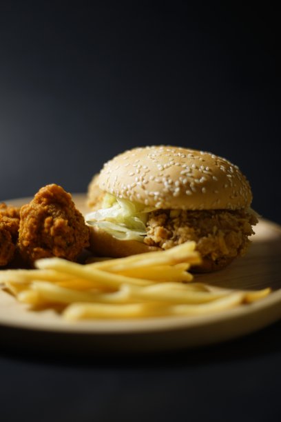 汉堡包、薯条和鸡肉放在同一个盘子里。图片下载