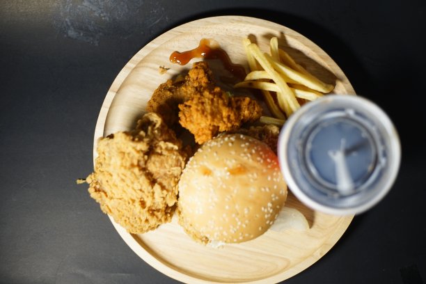 汉堡包、薯条和鸡肉放在同一个盘子里。图片下载