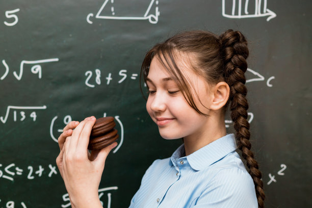 甜蜜时刻:在一张有趣的照片中，一个女学生正在享用巧克力松饼图片下载