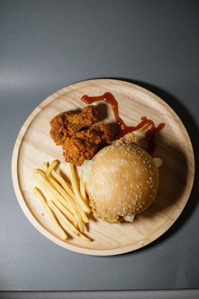 汉堡包、薯条和鸡肉放在同一个盘子里。图片下载