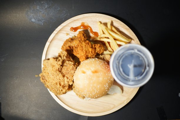 汉堡包、薯条和鸡肉放在同一个盘子里。图片下载