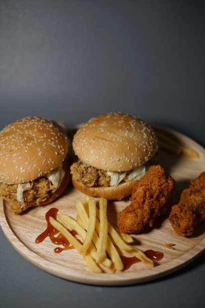 汉堡包、薯条和鸡肉放在同一个盘子里。图片下载