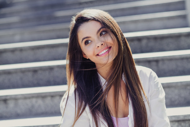 漂亮的有创意的女孩的照片，坐在楼梯上，看起来很感兴趣，很远，想象在市中心外面消磨时间，呼吸新鲜空气图片下载