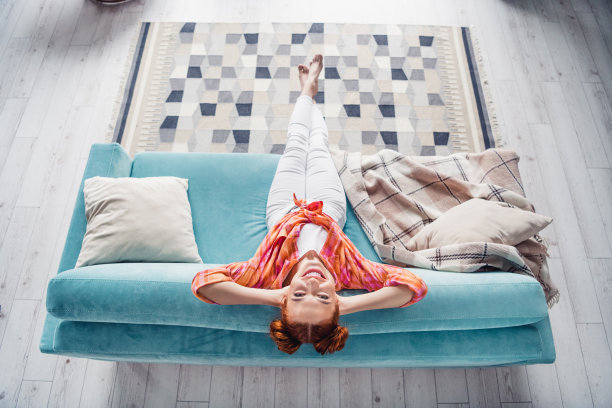 全尺寸高角度观看照片积极华丽的女孩坐在沙发手臂背后的头自由时间冷平里面图片下载