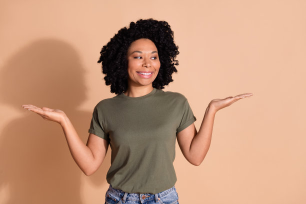漂亮的年轻女子的照片肖像比较看空空间穿着时髦的卡其布服装孤立的米色背景图片下载