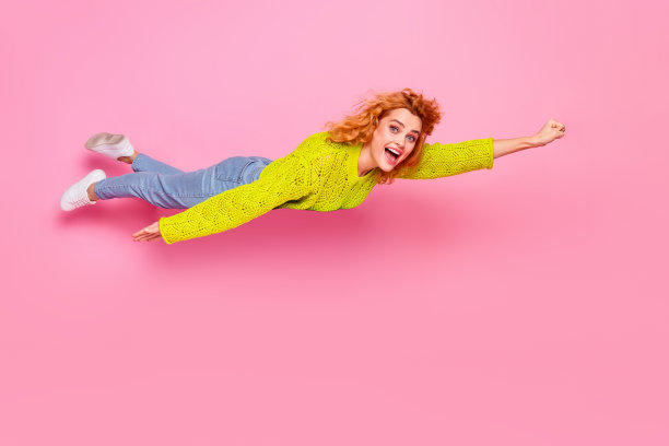 照片中有趣的兴奋开朗的女人穿着绿色时髦的衣服，首先匆匆帮助飞空孤立在粉红色的背景图片下载