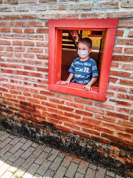 男孩在玩具屋的窗口玩耍-早上的例行公事图片下载
