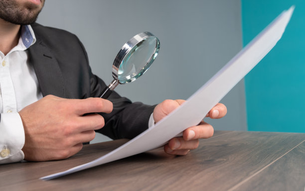 一个男人用放大镜检查文件图片下载