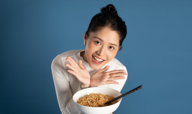 美丽的亚洲女孩在蓝色背景上摆姿势的肖像图片下载