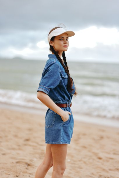 漂亮的年轻女士在海边享受暑假，展示她迷人的高加索美女和时尚的时尚。这张照片捕捉到了她在柔和的海风中飘逸的头发，背景是湛蓝的天空和波光粼粼的海水。题为图片下载