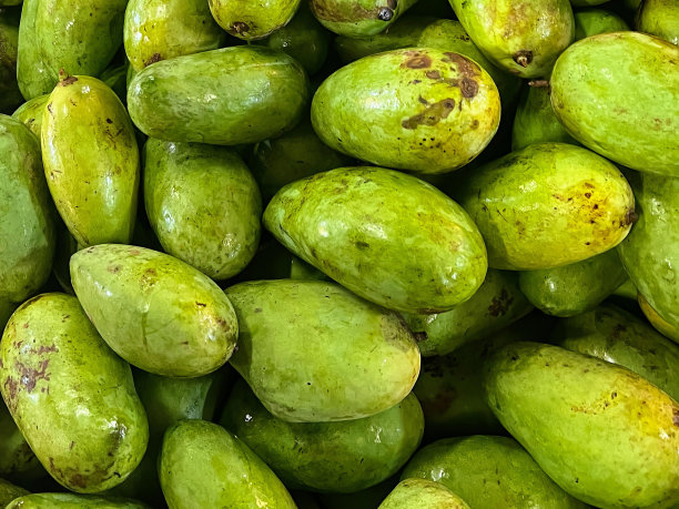 一堆带棕色斑点的绿色水果的照片。图片下载