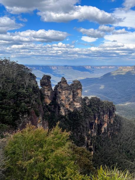 一个人站在悬崖上看山的照片。图片下载