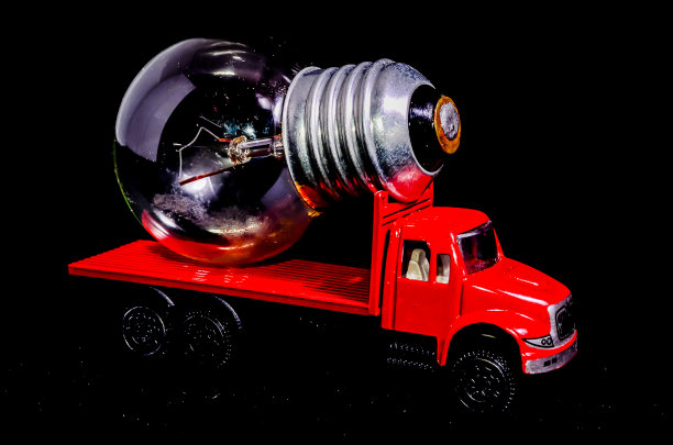 一辆红色的玩具卡车载着一个灯泡图片下载