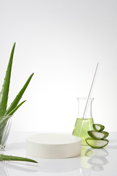 空底座放置在白色背景照片的中间，用芦荟装饰，一个带有淡绿色液体的erlenmeyer和一个装有芦荟的玻璃杯。显示产品的空白空间图片下载