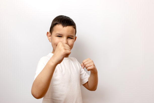 那男孩把拳头举到胸前，摆出一个格斗姿势。图片下载