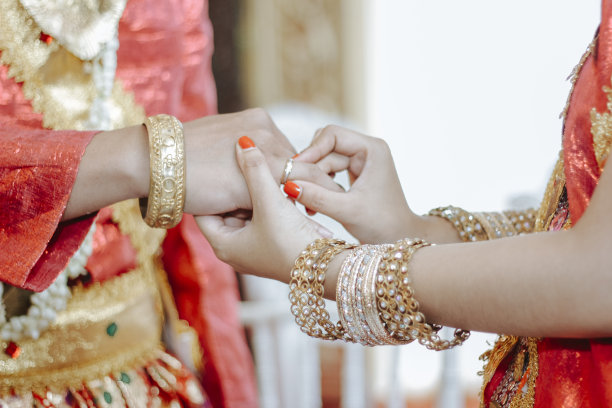 照片中的新娘正将戒指戴在新郎的手指上图片下载