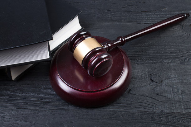 法律概念-在法庭或执法办公室的桌子上打开一本法律书，上面放着一个木制的法官木槌，背景是白色的。前视图。图片下载