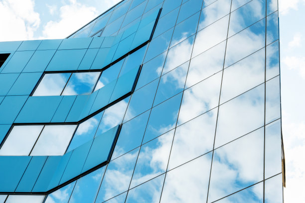 玻璃和钢铁的现代立面与反射。天空的抽象或图形照片，云似乎继续进入建筑与反射方形的玻璃图片下载