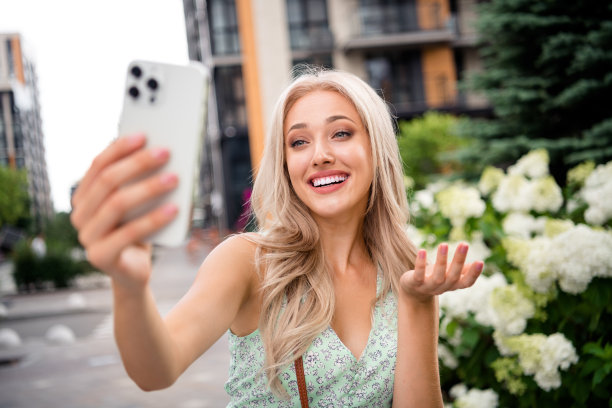 开朗的漂亮女孩的照片说视频电话谈论旅行游览大现代城镇大都市图片下载