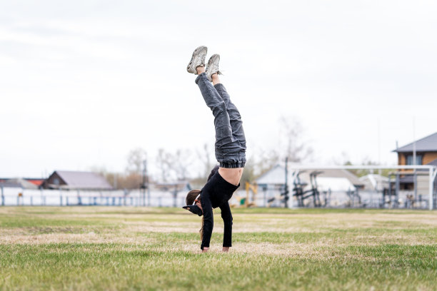 这位运动员倒立着。戴着猫面具和手套的少女在做Quadrobics。戴着猫面具的女孩跳得像只猫图片下载