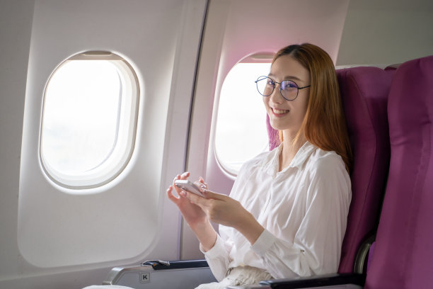 商务女性通过在飞机上休息和拍照来放松图片下载