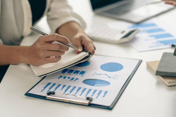 商人分析公司财务报告，资产负债表，处理文档图表保存股票市场照片，办公室，税单，特写照片。图片下载