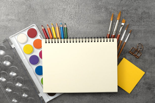 书和水彩颜料集和画笔上的石头纹理背景。办公桌空间图片下载