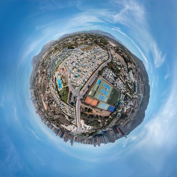 在一个阳光明媚的夏日，无人机拍摄了西班牙贝尼多姆小镇的360度全景照片，展示了一个带有游泳池和网球场的房车公园图片下载