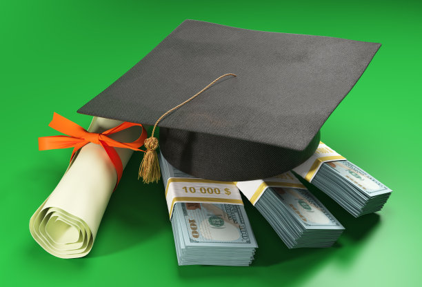 一堆美元上的学位帽。图片下载