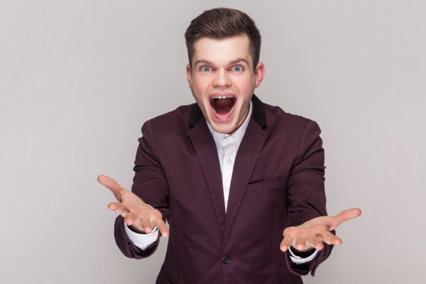 惊讶惊讶的英俊年轻人举起双臂，表示兴奋，看起来很惊讶。图片下载