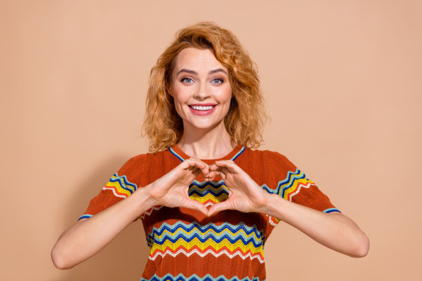 印象深刻的惊讶的女人穿着装饰t恤的照片，表明看标志空白的空间孤立在柔和的颜色背景图片下载