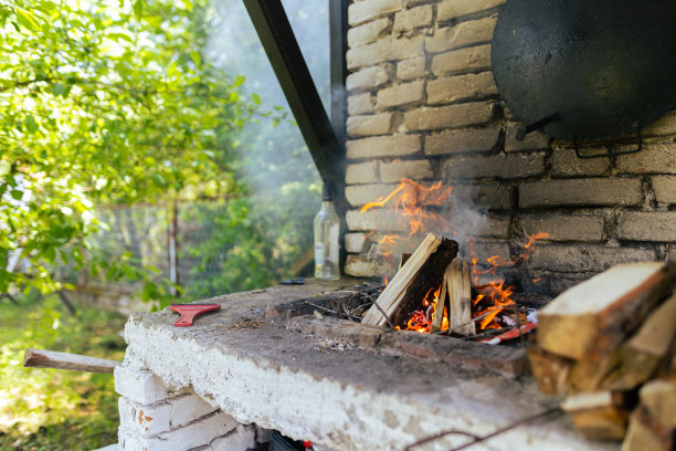 红色的火焰从一棵树的切割，深灰色的煤在一个金属火盆。木柴在火盆里燃烧着明黄色的火焰。火焰准备烧烤满足库存照片…没有人，拷贝空间图片下载