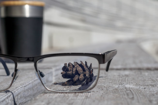 木凳上放着眼镜，背景是眼镜后面的松果图片下载