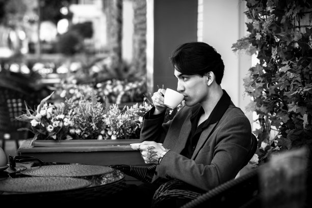 西装革履的亚洲帅哥坐在咖啡馆里。模糊的照片图片下载