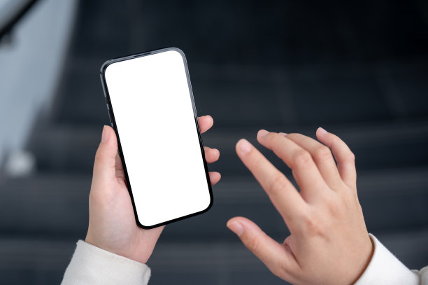 一个女人在走下楼梯时使用智能手机的特写照片。图片下载