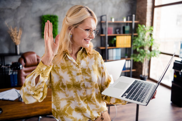 可爱的高级女士的照片肖像拿着上网本视频通话挥手穿着时髦的衬衫办公室日光家室内工作空间图片下载