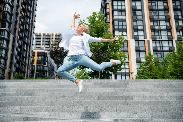 照片中快乐开朗的漂亮女孩在市中心的户外玩得很开心，跳起来高兴的季节性销售商场图片下载